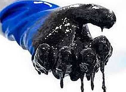 Hand wearing a glove dipped in tar