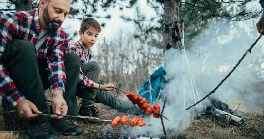 Father and Son Roasting Hot Dogs over Fire