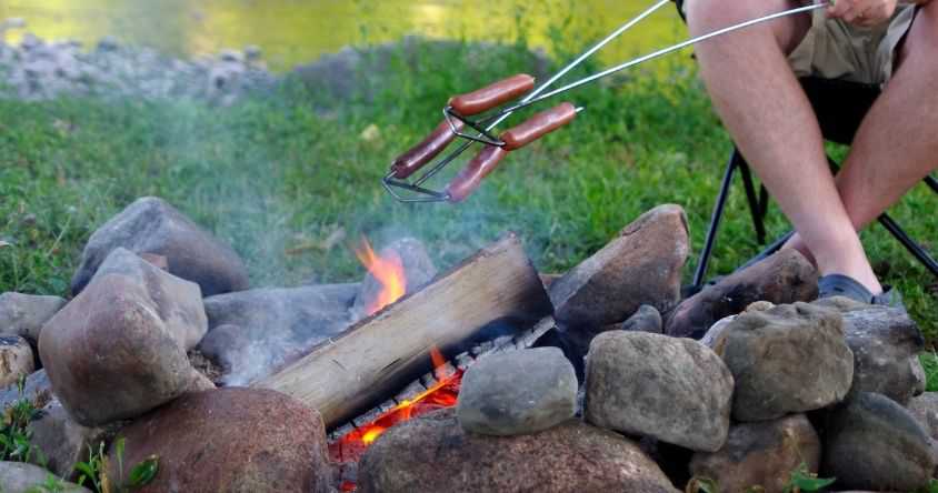 Person Roasting Hotdogs over Fire